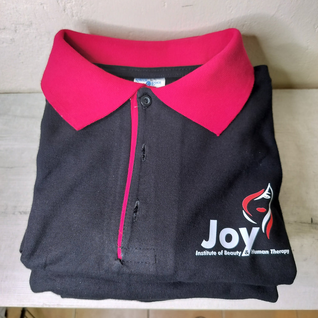 Folded black polo shirt with pink collar .